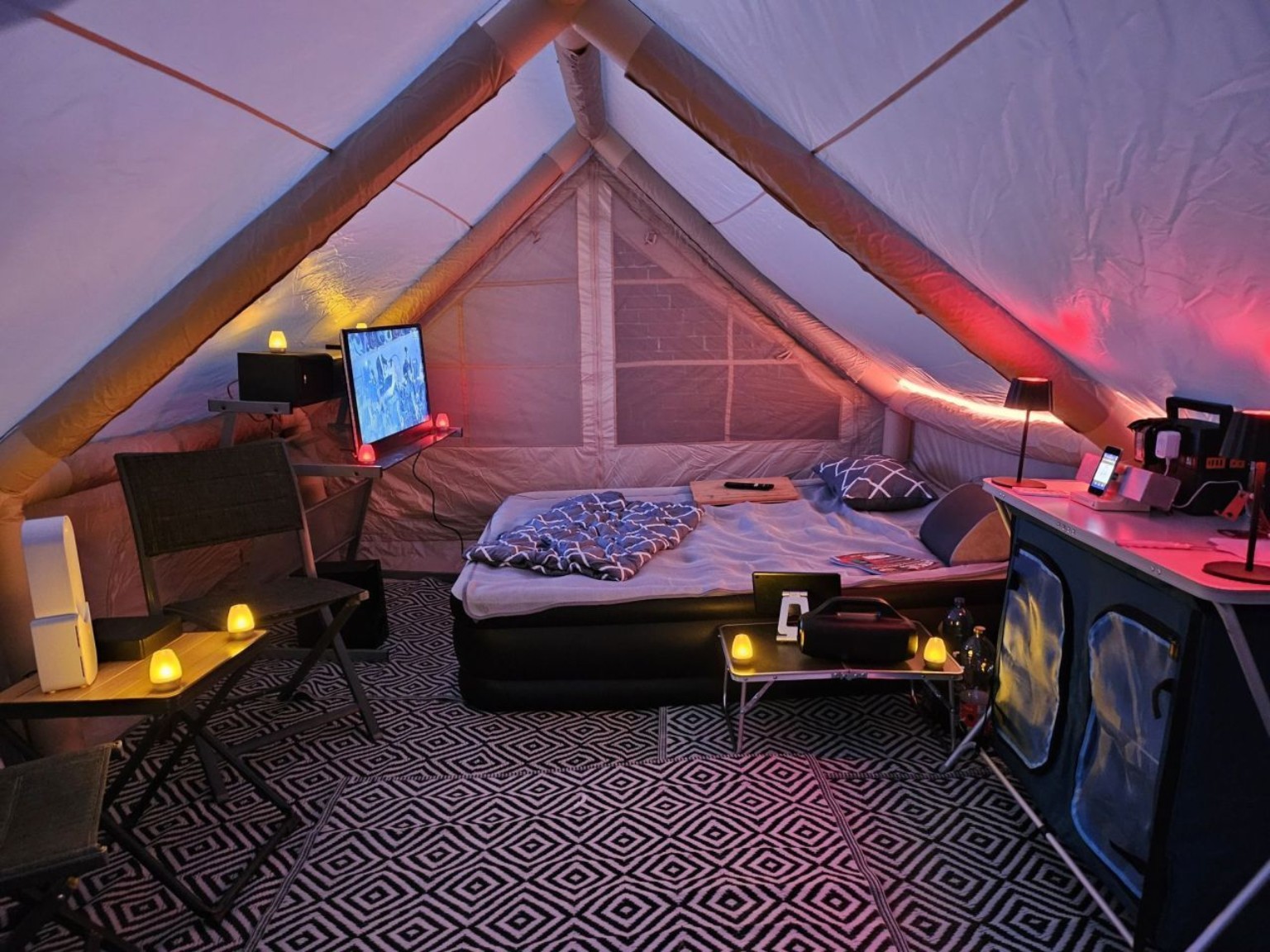 Innenraum des Glamping-Zelts mit Bett, Technik und stimmungsvoller Beleuchtung